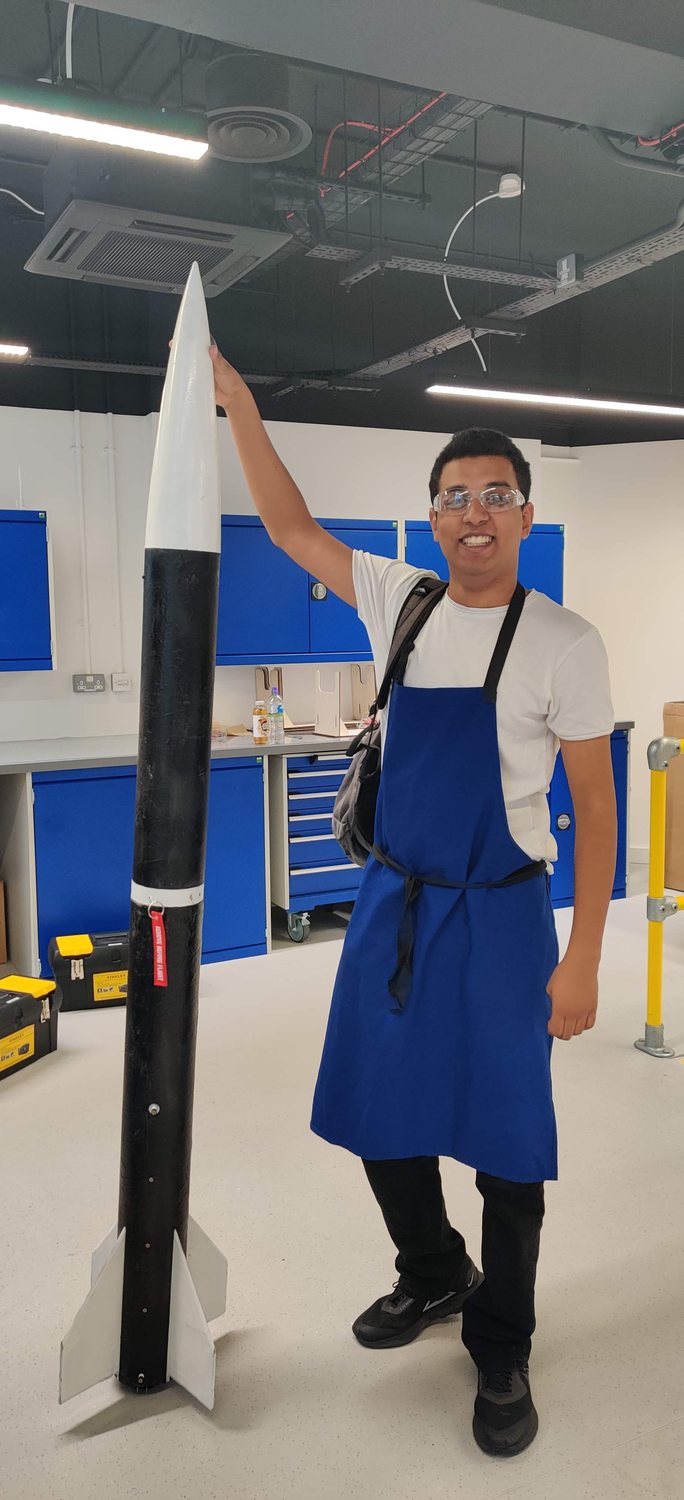 Holding our competition rocket, with the CanSat payload nose section at the top